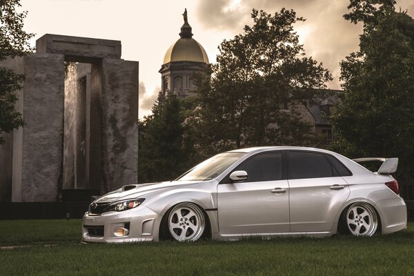 Light gray subaru on the background of an old temple