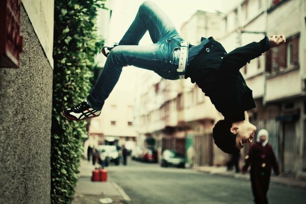 Der Kerl macht einen Salto auf der Straße