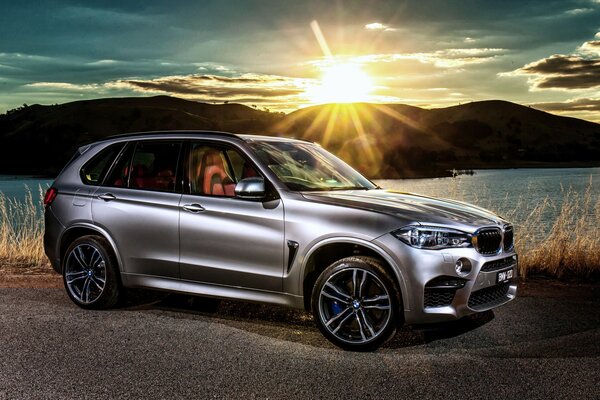 Gris BMW en el fondo de la puesta de sol, qué hermoso