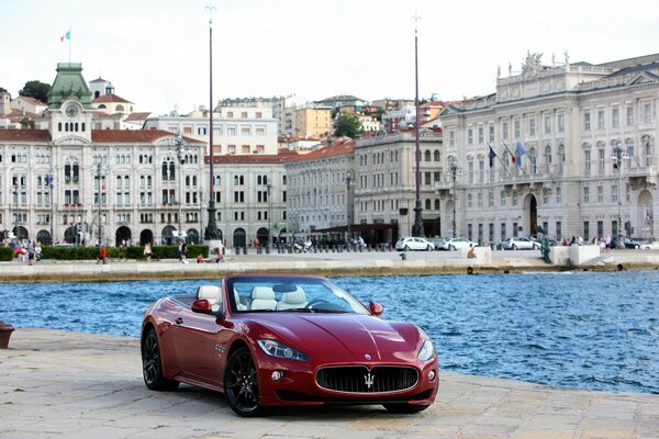 Maserati rojo en el fondo de una hermosa ciudad