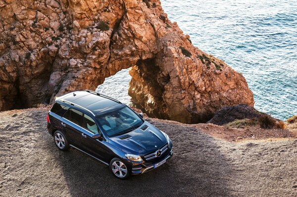 Blauer Mercedes amg gle 63s 4matis w166 auf dem Hintergrund von Felsen und Meer