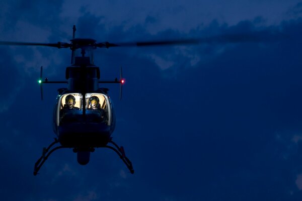 Helicóptero con cabina iluminada flotando en el aire