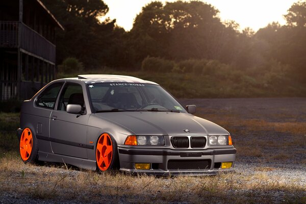 Grey BMW with tuning at sunset