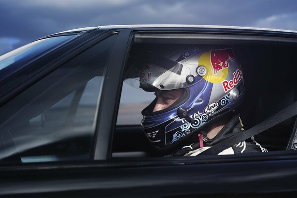 Piloto en coche con casco con Toro rojo