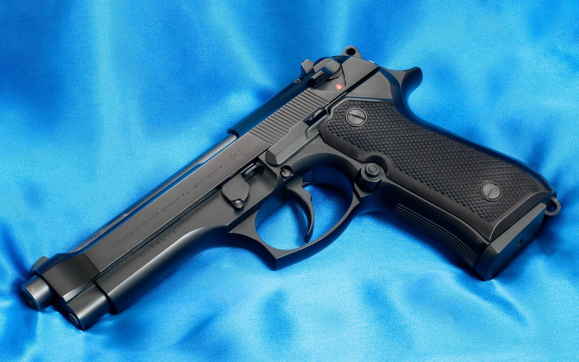 pistola 9mm beretta beretta 92f canna tela tessuto raso tessile sfondo blu