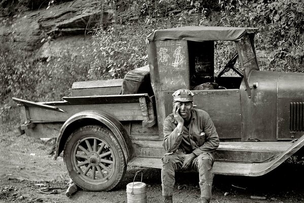 Foto en blanco y negro de un trabajador de vacaciones cerca de un camión