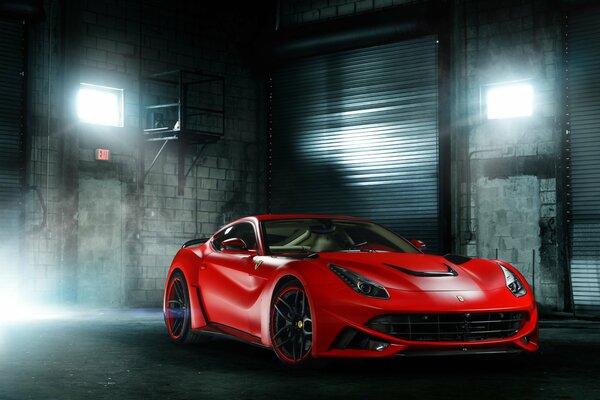 Elegante Ferrari rojo en el resplandor de las luces