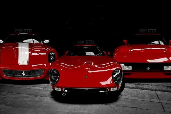 Trzy czerwone włoskie samochody na ciemnym tle
