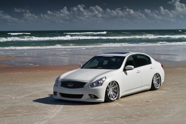 Bianco Infiniti sulla spiaggia vicino al mare