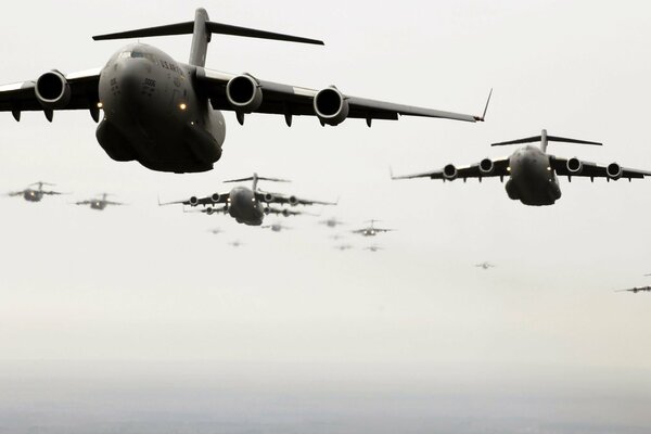 Много военных самолетов летит над небом