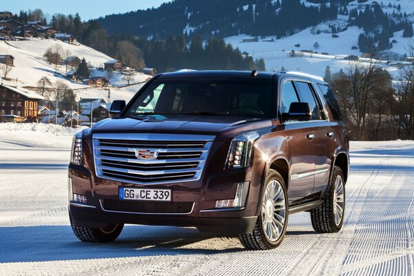 Коричневый cadillac escalade в горах