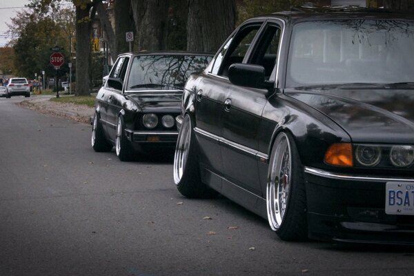 Two black cars racing down the road