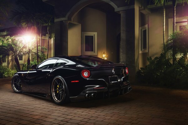 Black Ferrari at night near the house