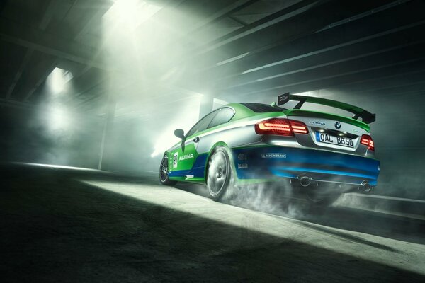 Smoke from under the wheels of a green sports car