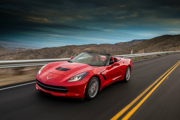 Rote Chevrolet Corvette auf dem Hintergrund der Berge auf dem Desktop