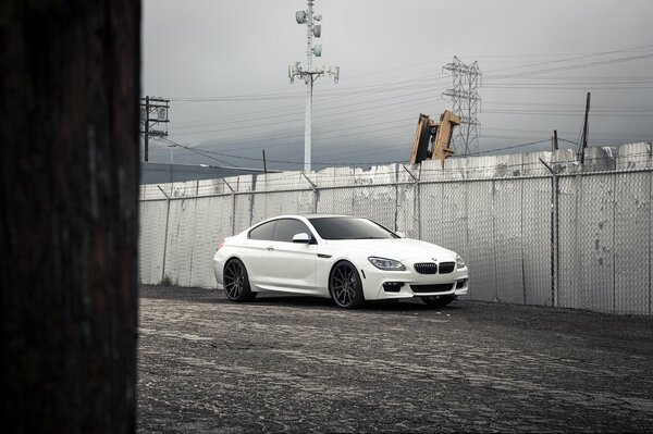 Weißes BMW-Auto auf Zaunhintergrund