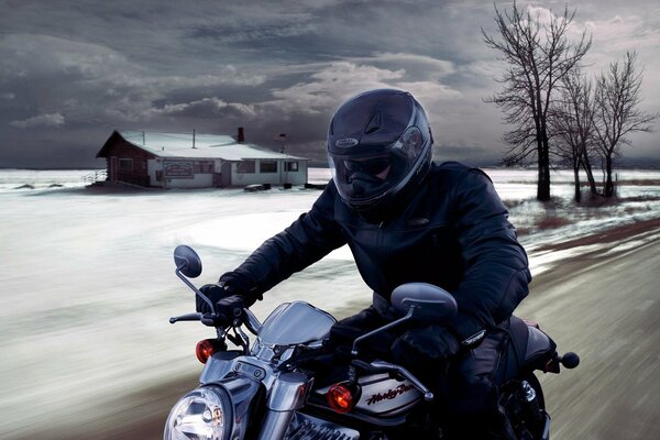 Ragazzo in casco su una moto sullo sfondo di un paesaggio invernale