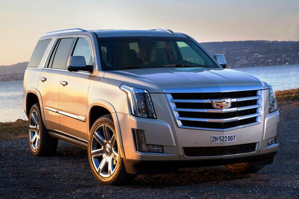 Silver cadillac escalade on the shore