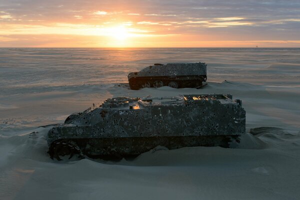 Armored vehicles in the desert sands at sunset