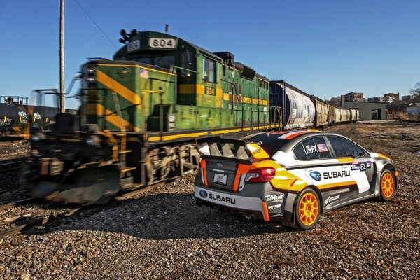 Tren y Subaru en el ferrocarril