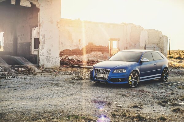 Blauer Audi auf dem Hintergrund der Ruinen