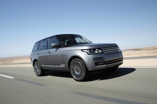 Range Rover guida veloce su una pista nel deserto