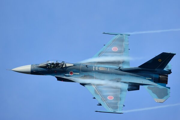 Blue fighter jet on a clear sky background