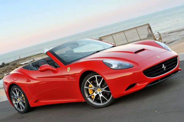 Red sports Ferrari on the background of the sea