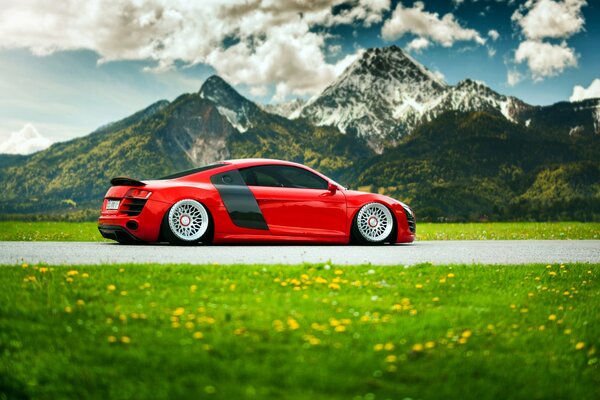 Audi rossa cavalca attraverso le montagne