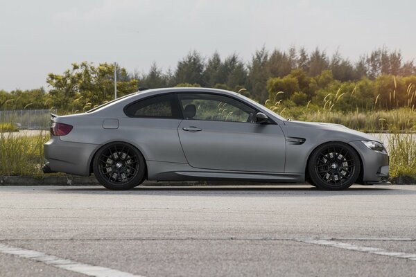 Gris BMW M3 sur fond de forêt