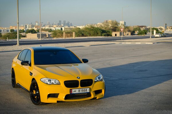 BMW amarillo. Coche brillante en la ciudad