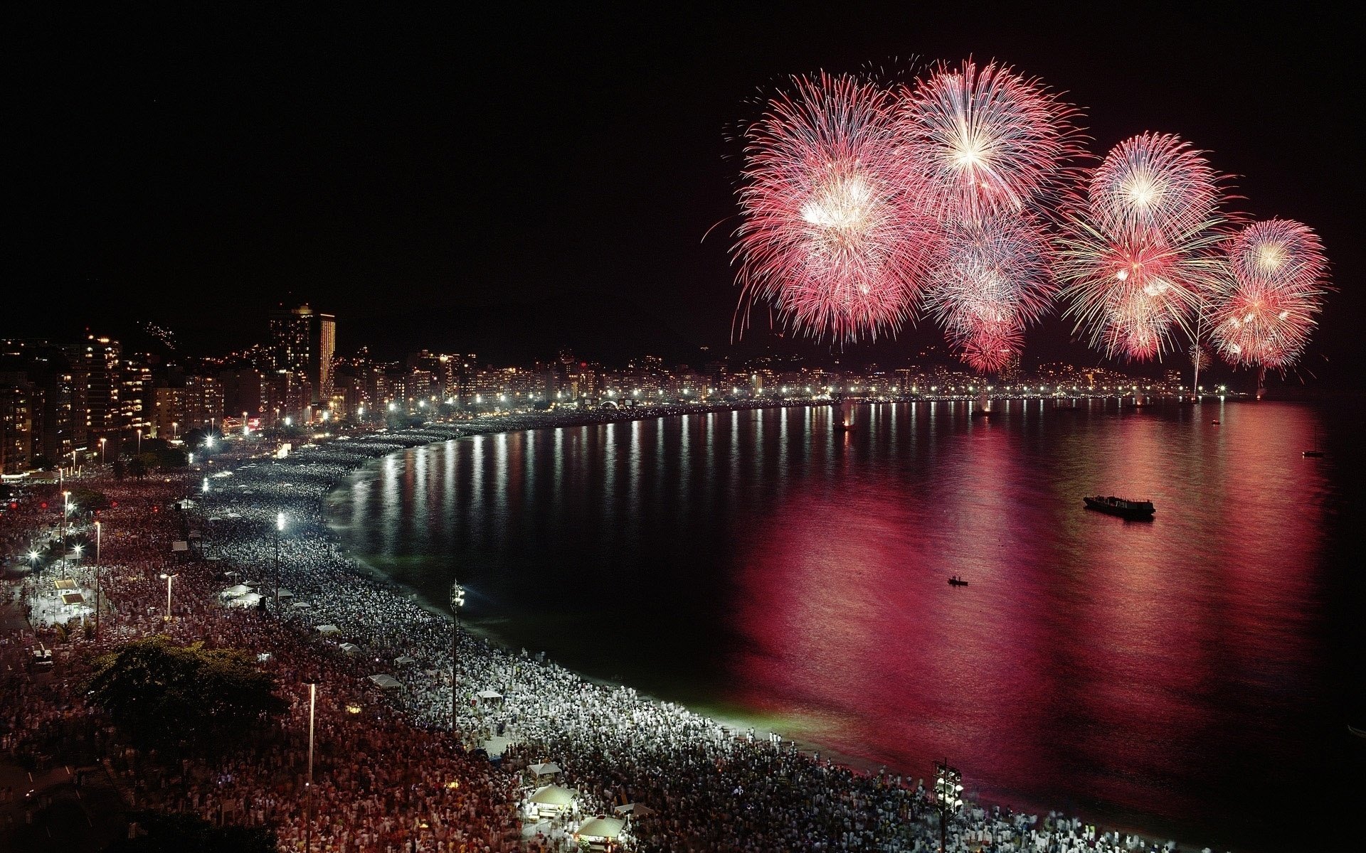 noche ciudad costa saludo gente multitud mar cielo luz linternas alegría reflexión vacaciones costa fuegos artificiales agua