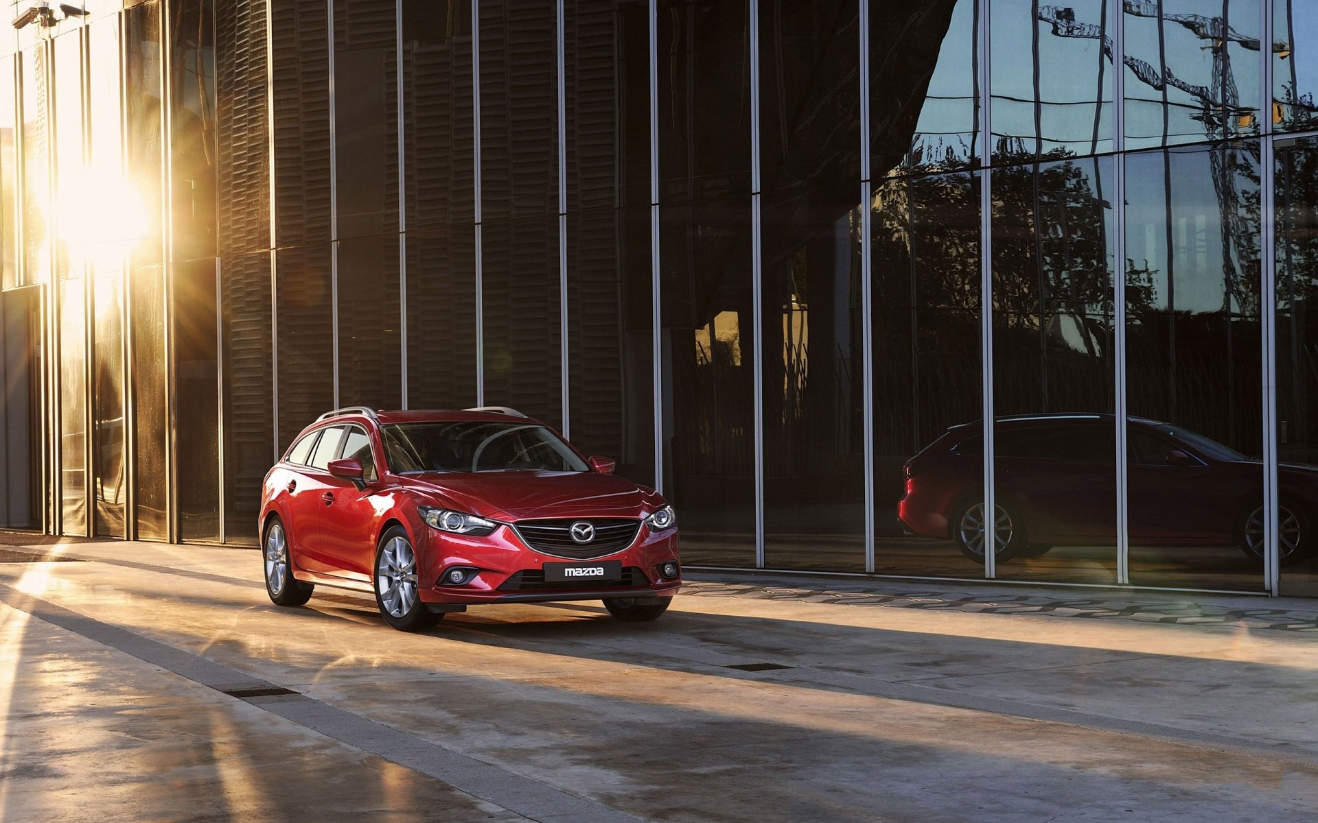 mazda wagon mazda sześć czerwony.przód budynek słońce tło