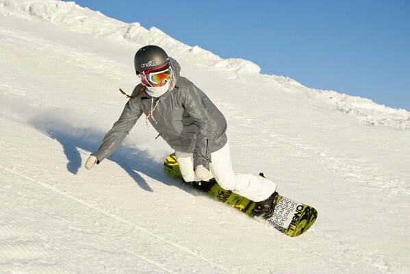 Winter sky when descending from the mountain winter flight of a girl on a snowboard