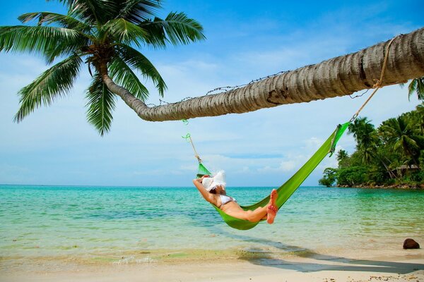 Ragazza che si rilassa in un amaca sulla spiaggia