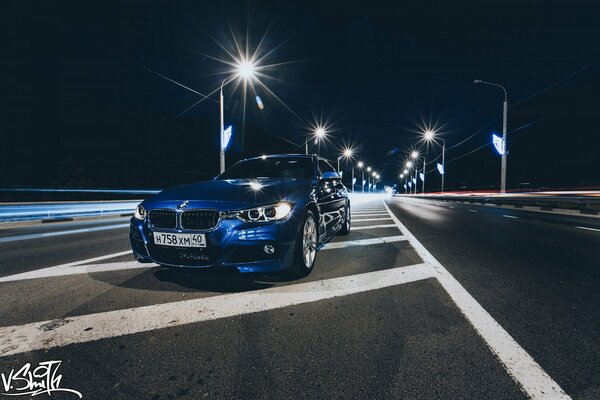 Ein blaues Auto in einer Nachtstadt