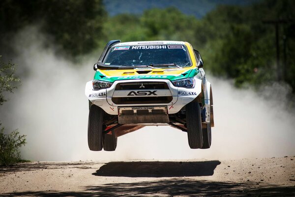 SUV mitsubish en el aire a la velocidad en la carrera de Dakar