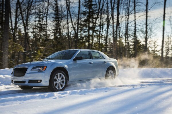 Chrysler vuela por un camino forestal cubierto de nieve