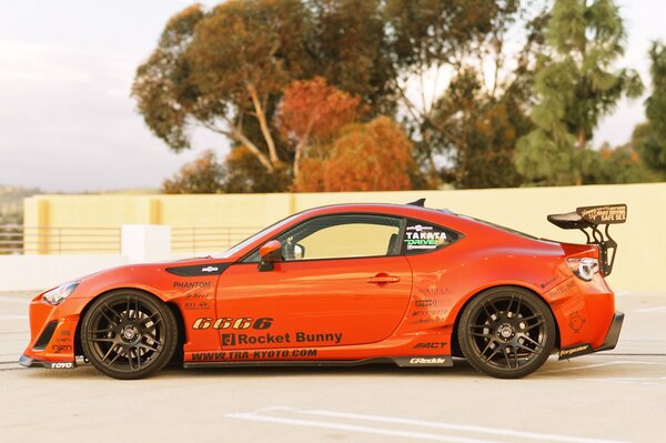 Voiture de sport orange se dresse sur la route