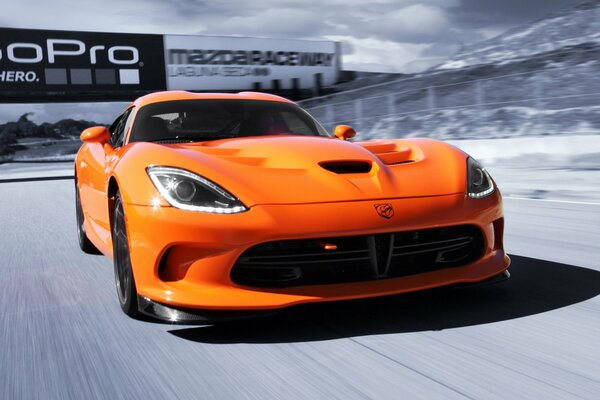 Picture of an orange viper car driving on the highway