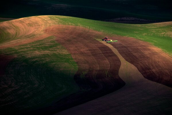 Foto scattata dall alto, campo dove funziona il trattore, crepuscolo