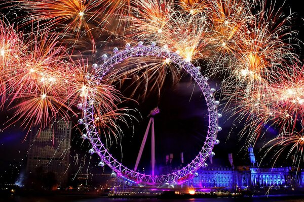 Bright colors of fireworks over the Ferris wheel