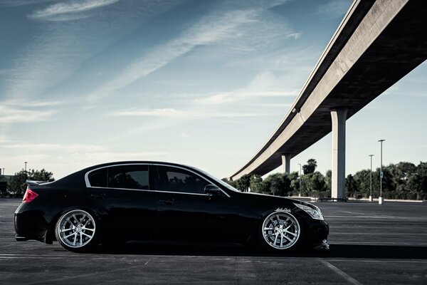 Voiture noire Infiniti g37 se tient sous le pont