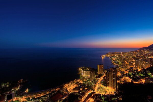 The night city glows on the seashore