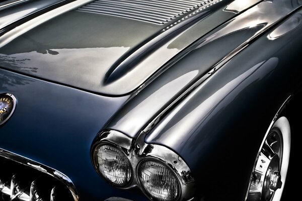 The hood of a blue classic Chevrolet car is up close