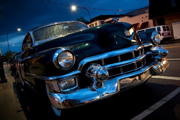 An old black cadillac on a night street