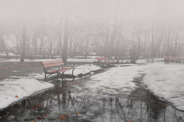 Es ist bewölkt, kalt und Schnee liegt im Park