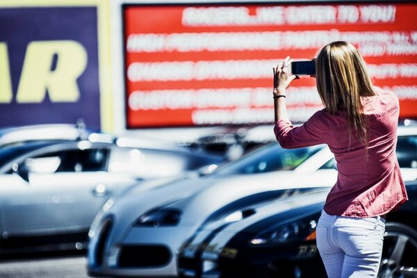 Mädchen auf dem Hintergrund der schönen Autos