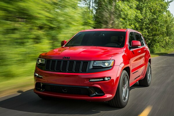 Jeep ancho rojo corriendo por la pista