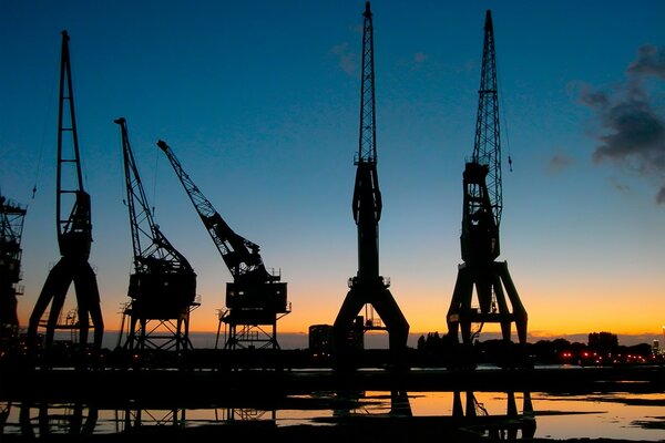 Grúas en el puerto en medio del cielo al atardecer